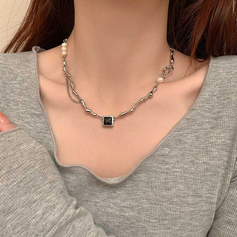 Lyra naszyjnik z czarnym kamieniem i perłą – elegancka biżuteria wyrazista