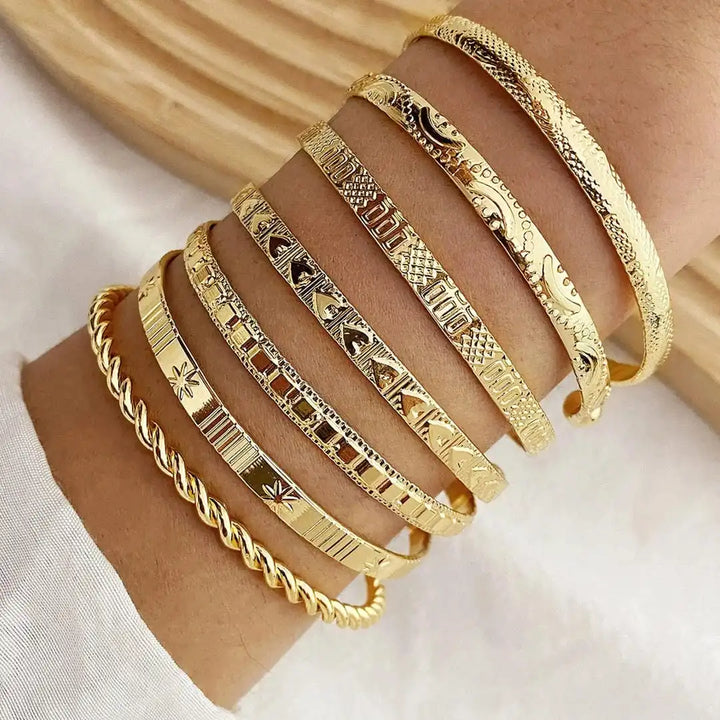 Zestaw otwartych złotych bransoletek typu bangle